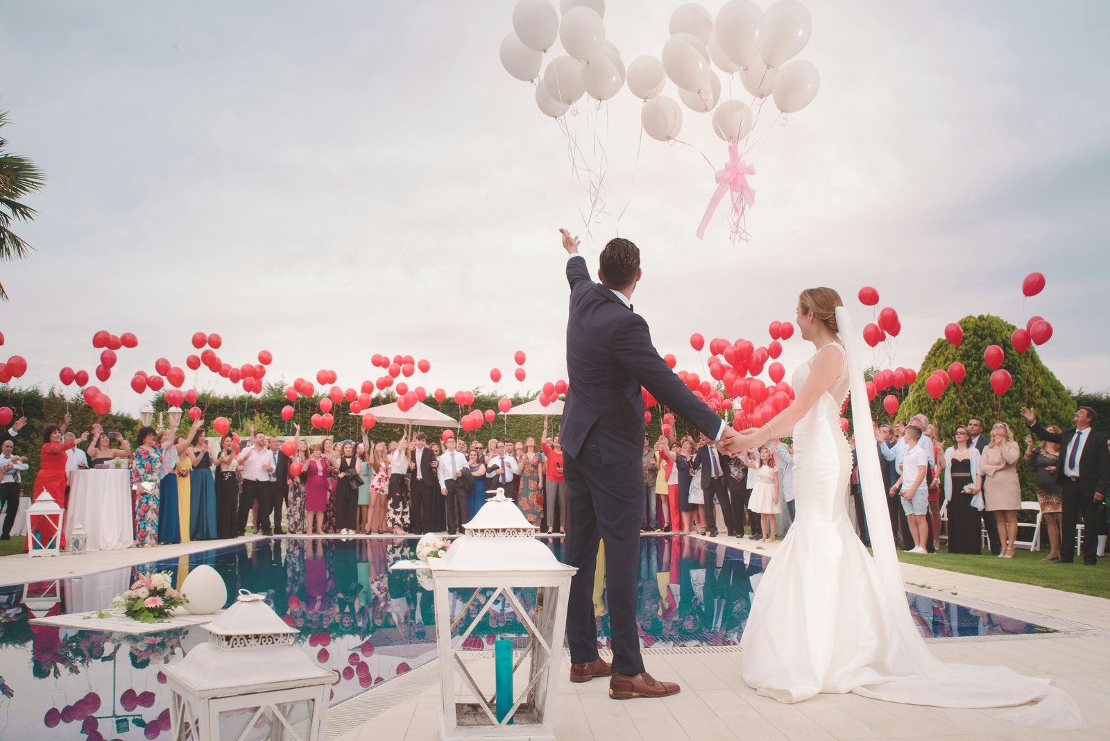 Bride and groom celebrating with wedding guests and balloons